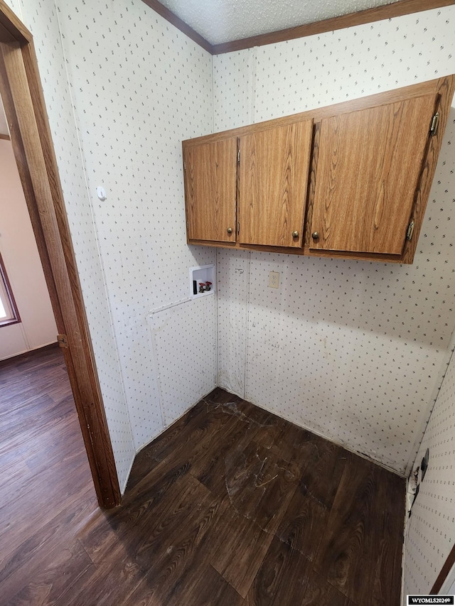 laundry area with cabinets, a textured ceiling, and dark wood-type flooring