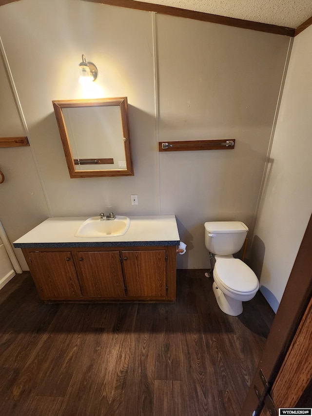 bathroom featuring vanity, crown molding, hardwood / wood-style flooring, toilet, and a textured ceiling