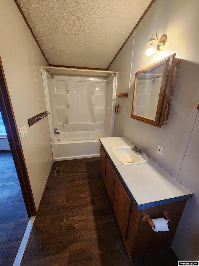 bathroom featuring shower / tub combination, vanity, a textured ceiling, and hardwood / wood-style flooring