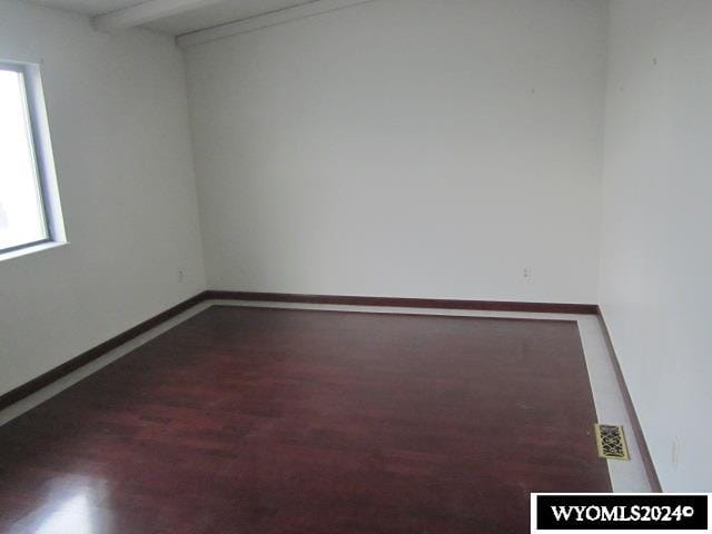 unfurnished room with dark hardwood / wood-style flooring