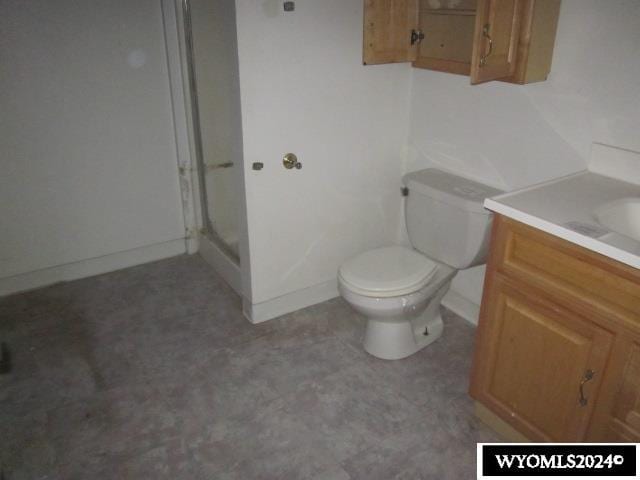 bathroom featuring vanity, toilet, and a shower with shower door