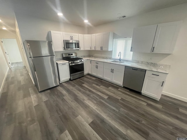 kitchen with dark hardwood / wood-style flooring, white cabinetry, sink, and appliances with stainless steel finishes