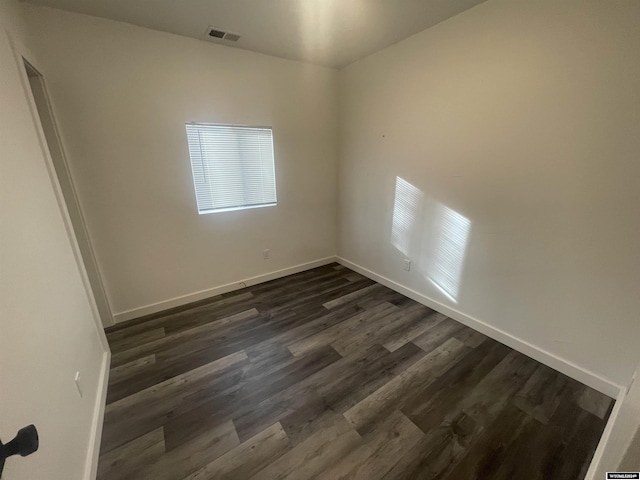 empty room with dark hardwood / wood-style flooring