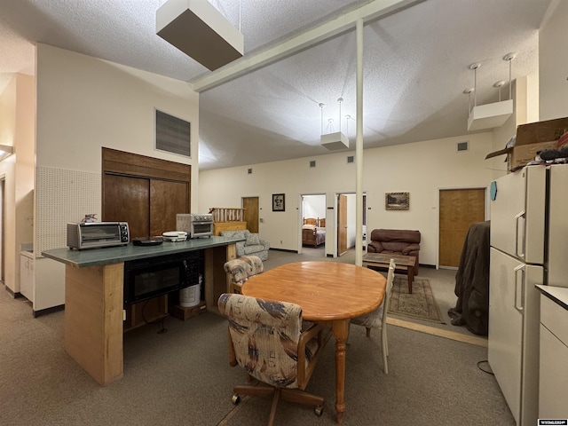 carpeted dining room featuring a textured ceiling