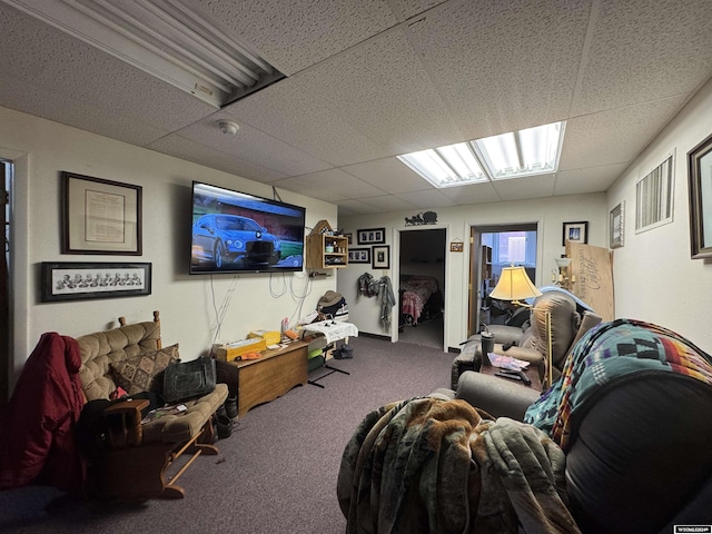 carpeted living room with a drop ceiling