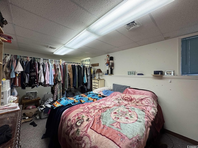 carpeted bedroom featuring a paneled ceiling