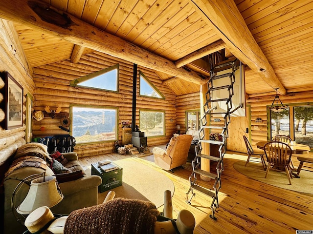 living room featuring vaulted ceiling with beams, light hardwood / wood-style flooring, log walls, and wood ceiling