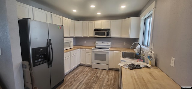 500 Madison, Rawlins, WY 82301 - kitchen featuring butcher block countertops, light wood-type flooring, recessed lighting, a sink, and stainless steel appliances
