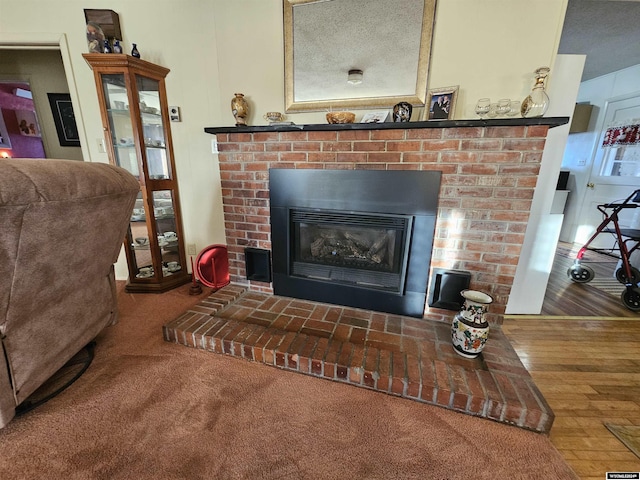 details featuring a textured ceiling, hardwood / wood-style flooring, and a brick fireplace