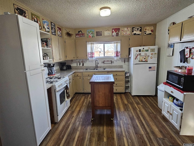 kitchen featuring dark hardwood / wood-style flooring, white appliances, a textured ceiling, sink, and a kitchen island