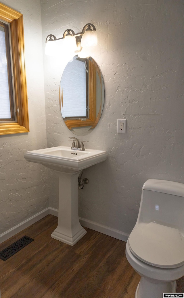 bathroom featuring hardwood / wood-style floors and toilet