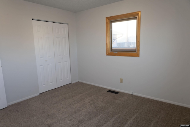 unfurnished bedroom featuring carpet and a closet