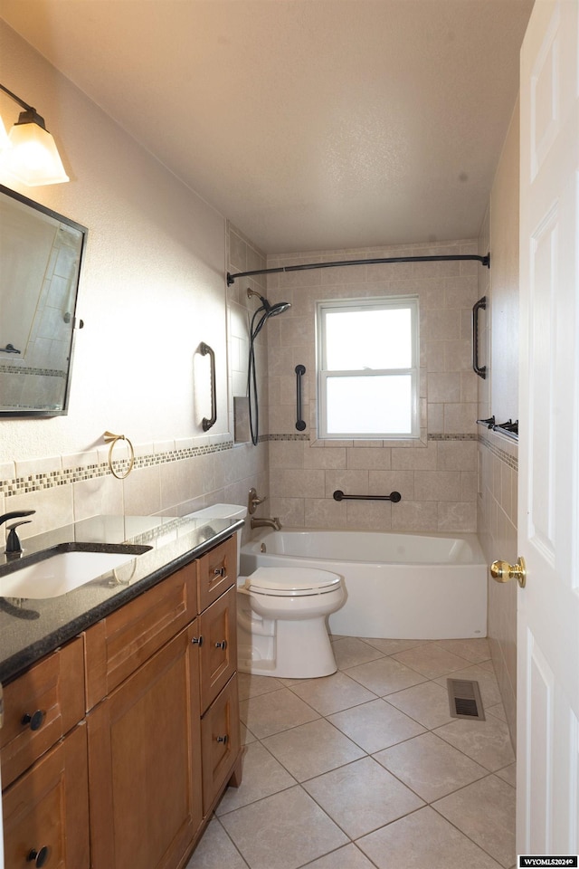 full bathroom with tile patterned floors, vanity, toilet, and tiled shower / bath combo