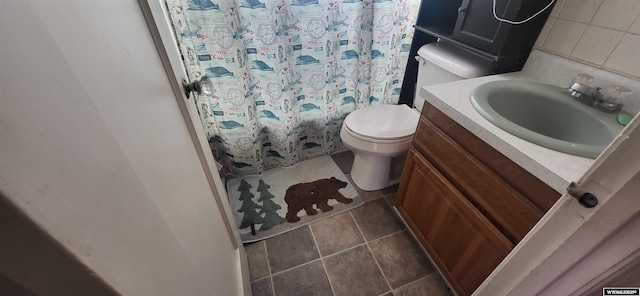 bathroom featuring tile patterned flooring, vanity, toilet, and walk in shower