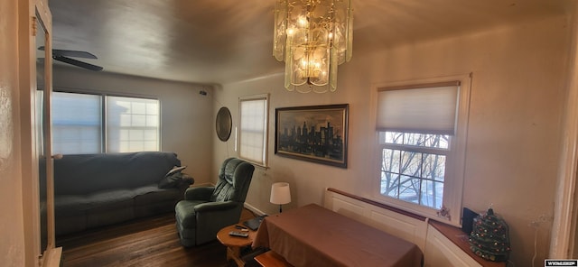 sitting room with plenty of natural light, dark hardwood / wood-style flooring, and ceiling fan with notable chandelier