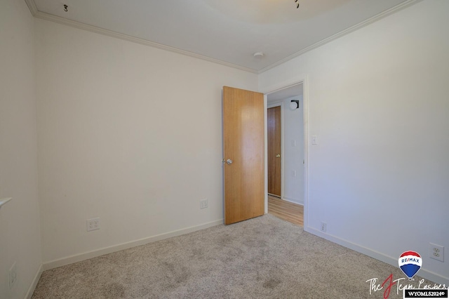 unfurnished room featuring light colored carpet and ornamental molding