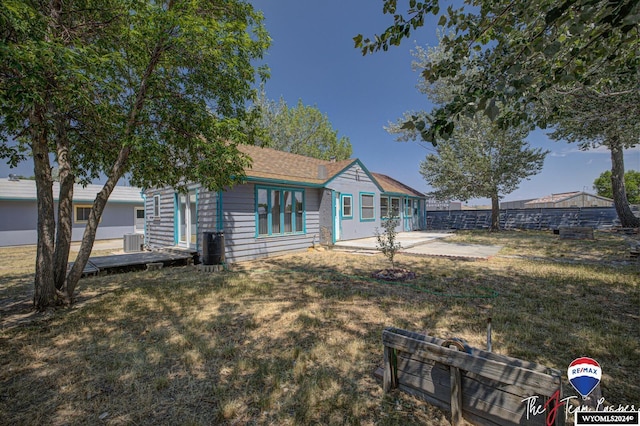 rear view of property featuring central air condition unit, a yard, and a patio