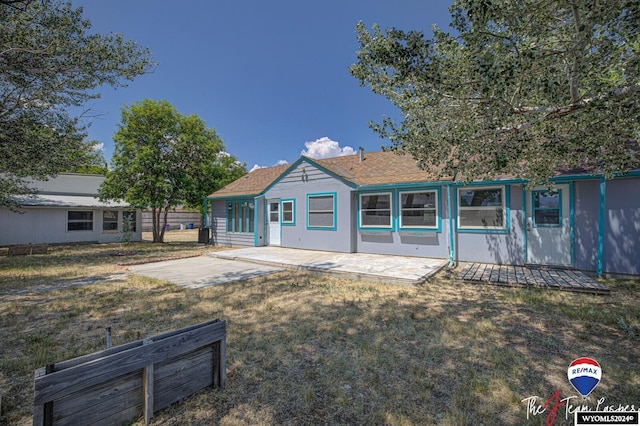 back of property featuring a lawn and a patio area