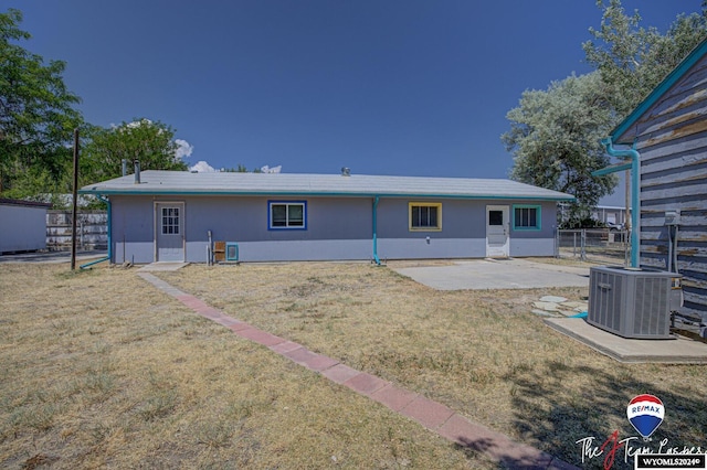 back of house featuring a lawn, a patio area, and central AC