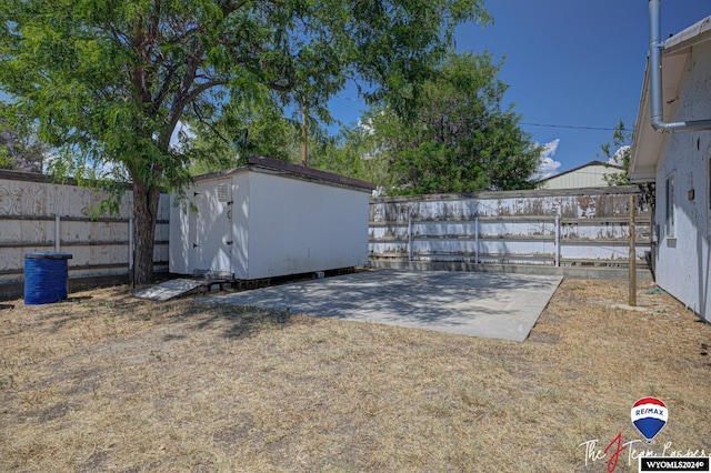 view of yard featuring a storage unit and a patio area