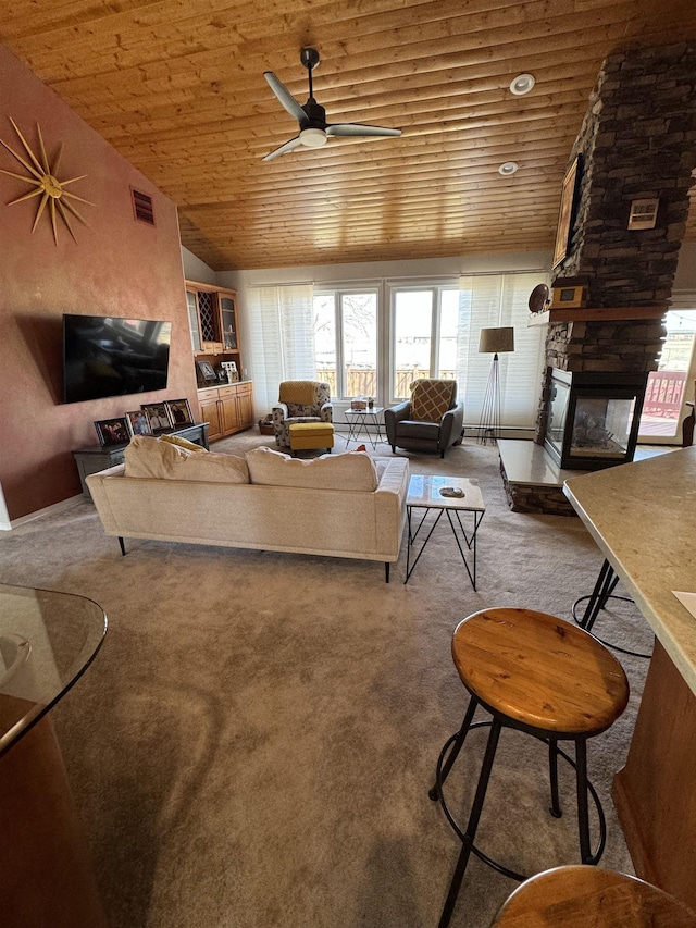 living room featuring lofted ceiling, wooden ceiling, ceiling fan, a fireplace, and carpet floors