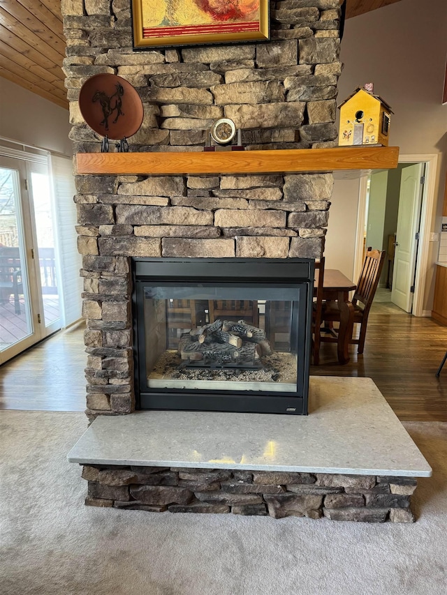 room details with a fireplace, wooden ceiling, and hardwood / wood-style flooring