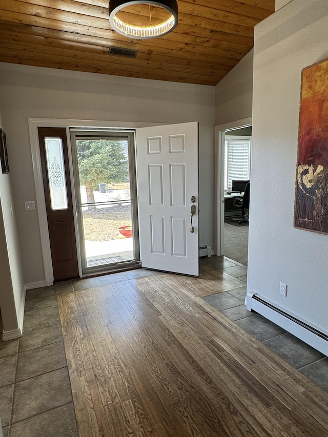 tiled foyer featuring vaulted ceiling, a baseboard heating unit, and wood ceiling