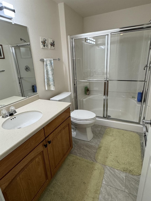 bathroom with vanity, a shower with shower door, and toilet