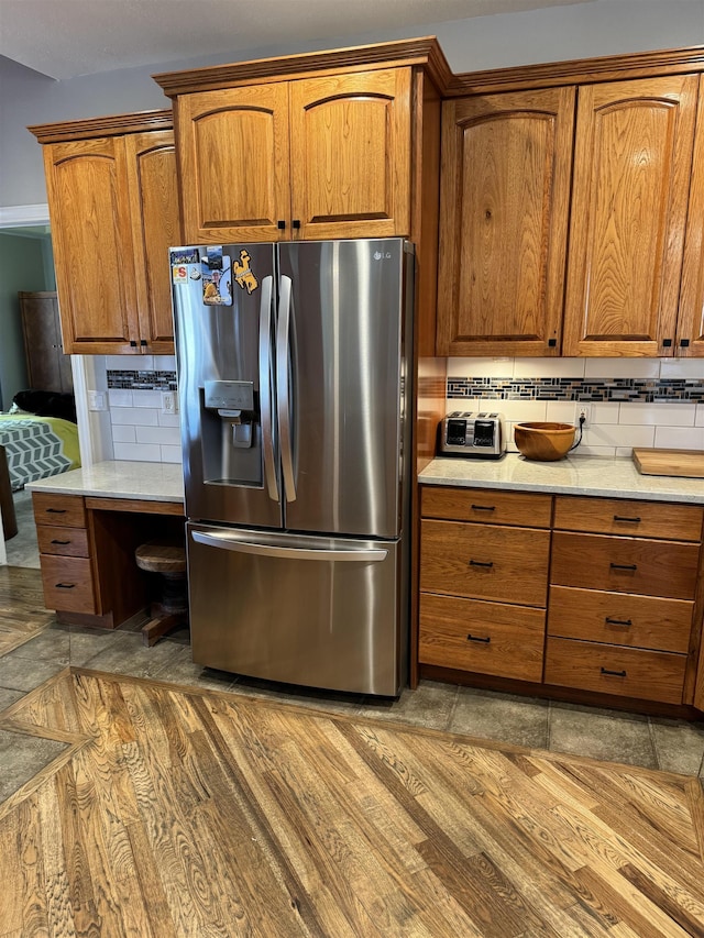 kitchen with stainless steel fridge and tasteful backsplash