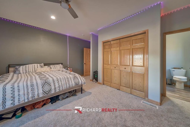 bedroom with carpet flooring, ceiling fan, a closet, and ensuite bathroom