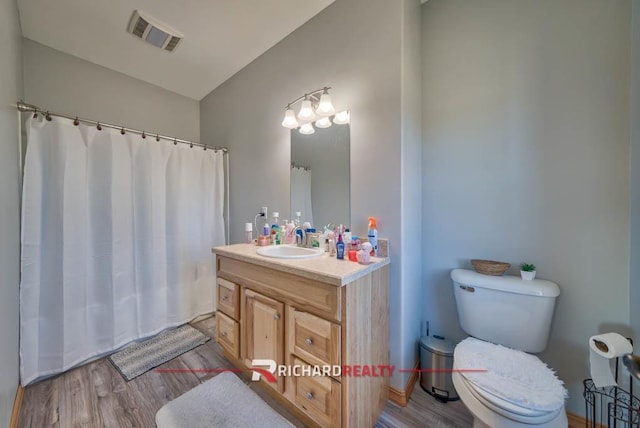 bathroom with vanity, toilet, and wood-type flooring