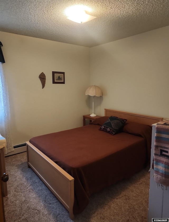 carpeted bedroom featuring baseboard heating and a textured ceiling