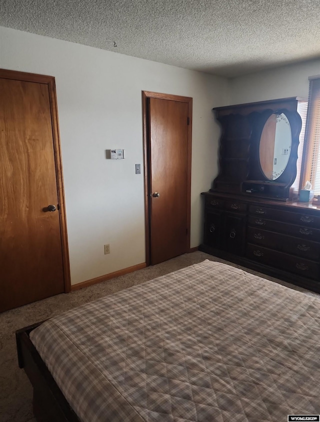 bedroom with a closet, carpet, and a textured ceiling