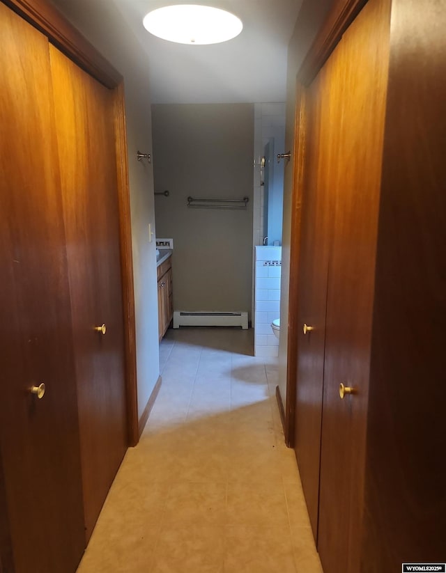 hall featuring light tile patterned flooring and a baseboard heating unit