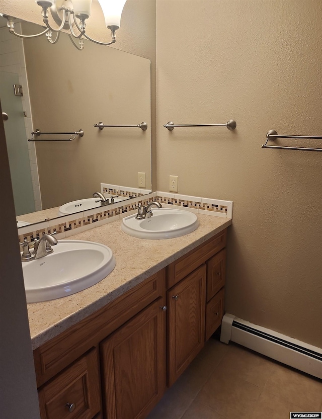 bathroom featuring tile patterned flooring, vanity, a baseboard radiator, and an inviting chandelier