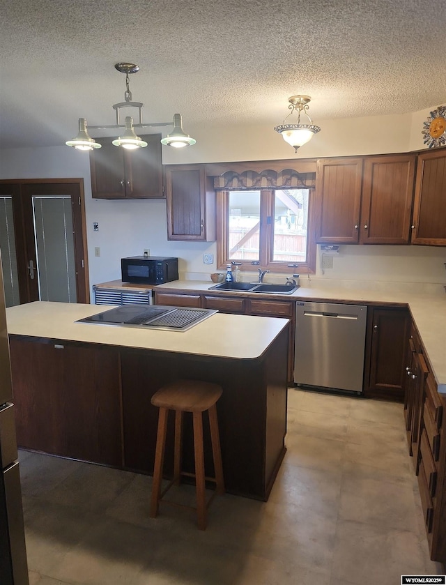 kitchen featuring dishwasher, pendant lighting, cooktop, and a kitchen island