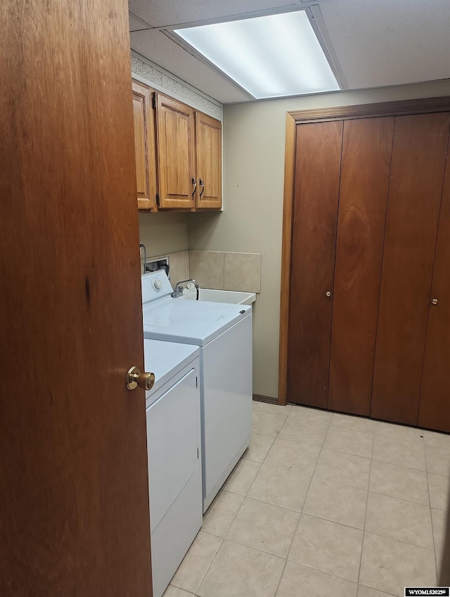 washroom with washer and clothes dryer, cabinets, light tile patterned floors, and sink