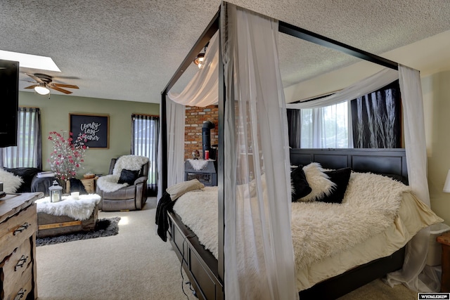 carpeted bedroom with ceiling fan and a textured ceiling