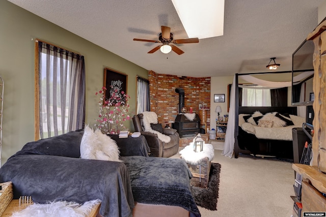 living room with a wood stove, plenty of natural light, and a textured ceiling