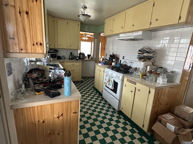 kitchen with tasteful backsplash and white range with gas cooktop