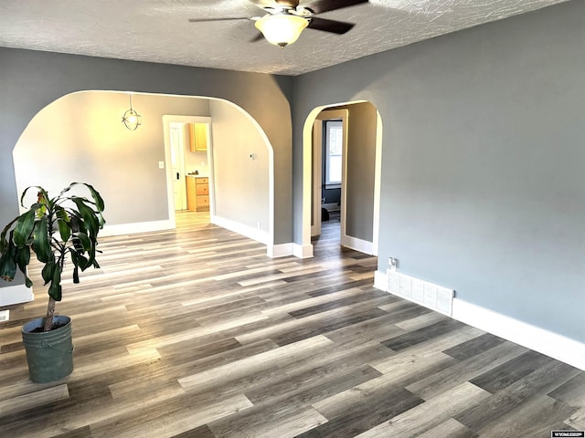 unfurnished room with wood-type flooring, a textured ceiling, and ceiling fan