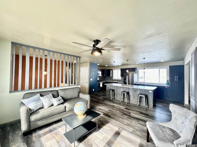 living room with dark hardwood / wood-style floors and ceiling fan