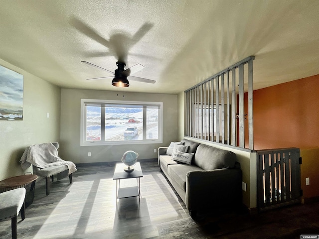 living room featuring ceiling fan and a textured ceiling