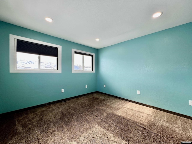 unfurnished room featuring dark carpet