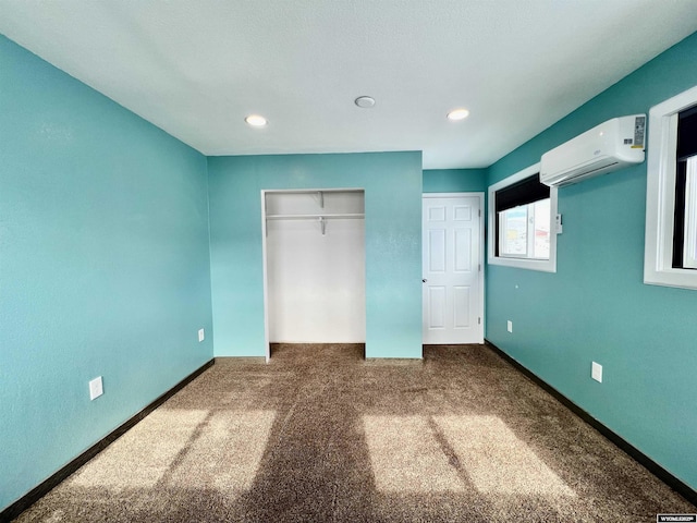 unfurnished bedroom featuring a wall unit AC and dark carpet