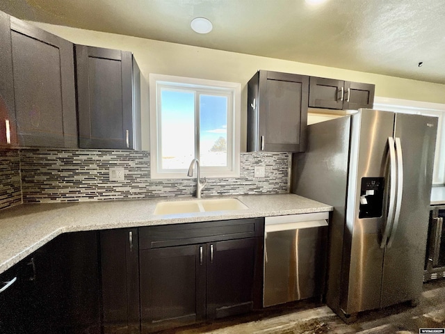 kitchen with sink, dark wood-type flooring, stainless steel appliances, decorative backsplash, and dark brown cabinets