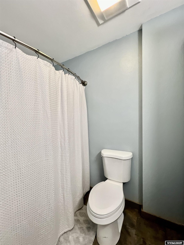 bathroom with a shower with shower curtain and toilet