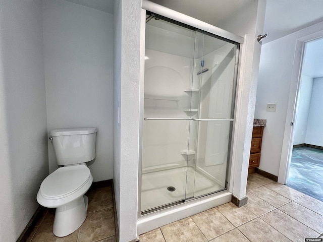 bathroom with tile patterned flooring, toilet, and a shower with shower door