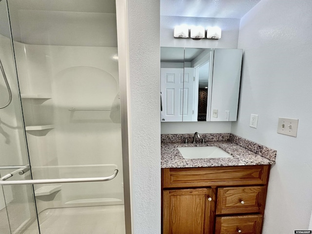 bathroom featuring a shower and vanity