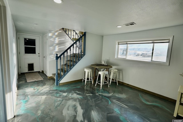 foyer entrance with a textured ceiling